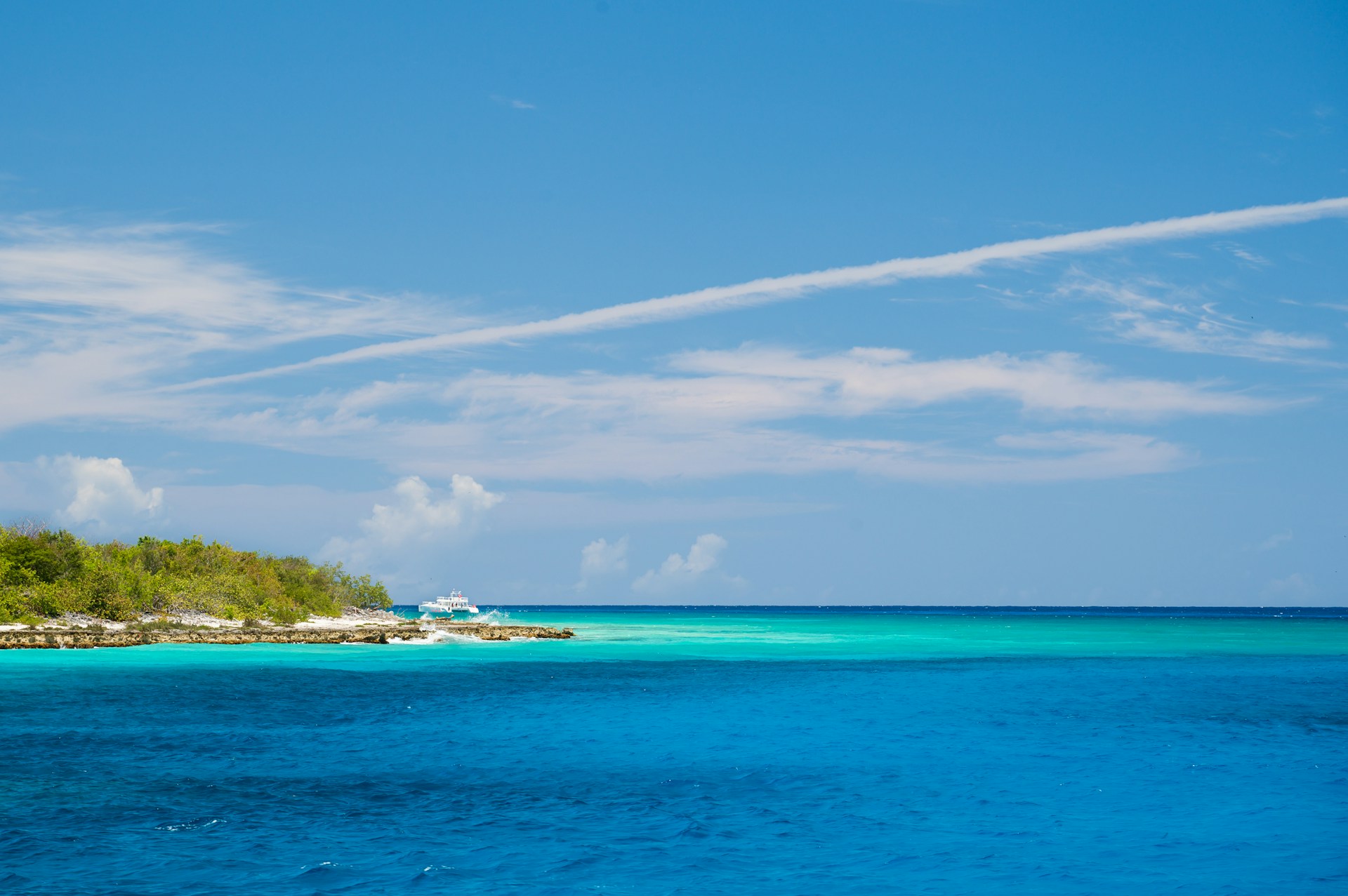 Low green coastline and turquoise Caribbean water at Catalina Island, Dominican Republic.