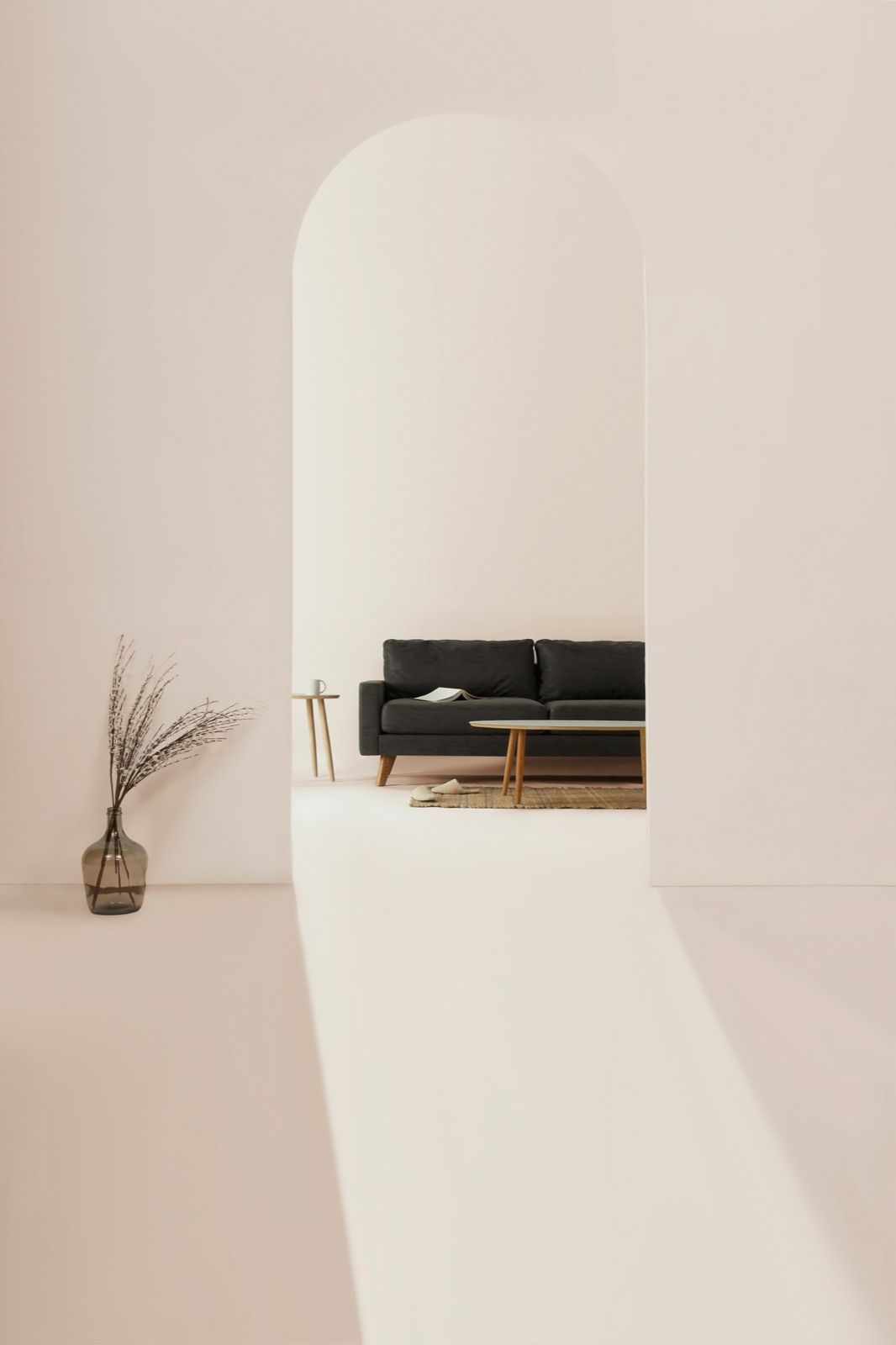 A pale arched interior with a dark sofa and low tables beyond it.
